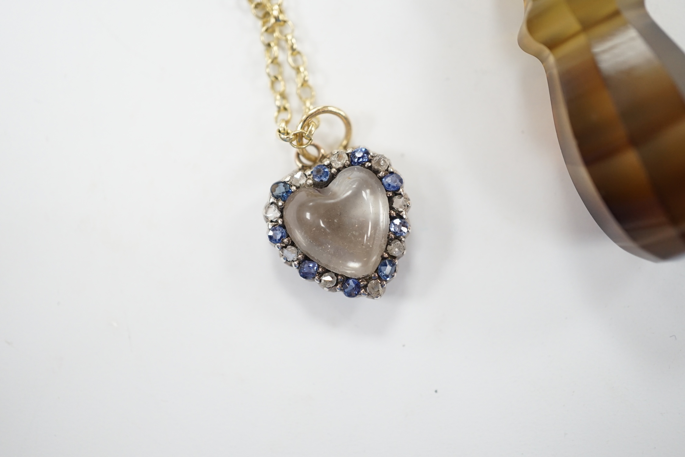 An early 20th century yellow metal, moonstone, sapphire and rose cut diamond set heart shaped pendant, 12mm on a yellow metal chain, together with a yellow metal mounted banded agate pendant, on a 9c chain. Fair conditio